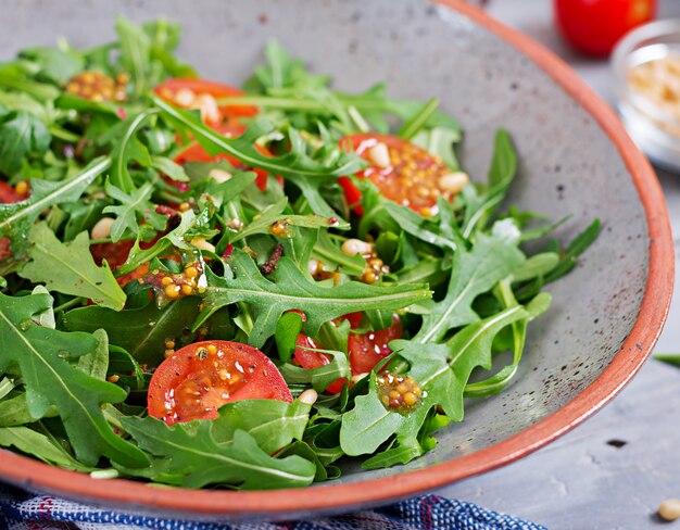 Menú dietético Cocina vegana. Ensalada saludable con rúcula, tomates y piñones.