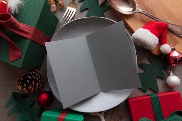 Menu em branco da refeição de Natal menu de papel em branco em um prato de jantar cercado por decorações festivas