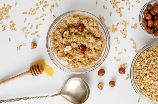 Menú equilibrado de alimentos dietéticos para el desayuno con un plato de gachas de avena con avellanas y miel