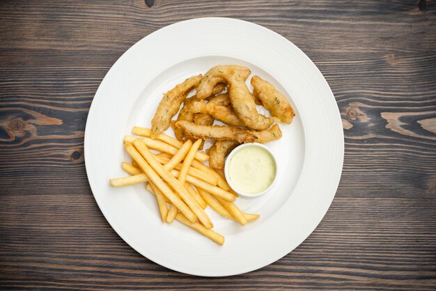 Menú con gambas fritas y patatas fritas con salsa en un plato