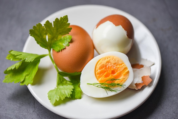 Menú de huevos comida huevos cocidos en un plato blanco decorado con hojas de eneldo verde y perejil, yemas de huevo cortadas a la mitad para cocinar un desayuno de huevos saludable