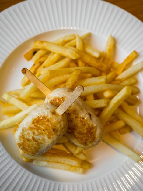 Menú infantil patatas fritas y chuletas de pollo en forma de paleta