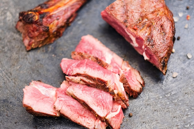 Menú de parrilla. Filete de vaquero. Primer plano de la vista superior de carne de res a la parrilla en rodajas y hueso.