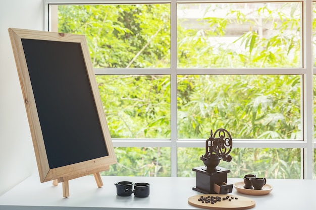 Menú de pizarra en la mesa de madera marrón oscuro con una taza de café