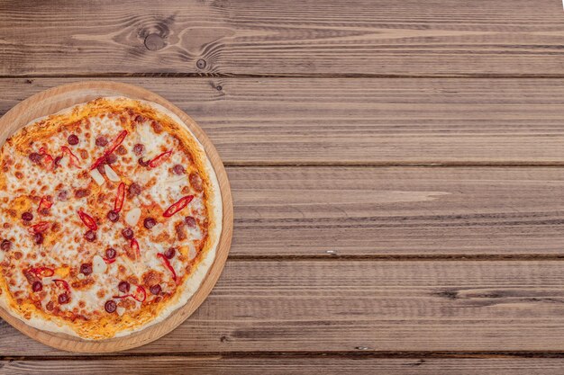 Menú de restaurante de pizza Deliciosa pizza picante con salchichas y pizza de chile en una mesa de madera rústica con ingredientes