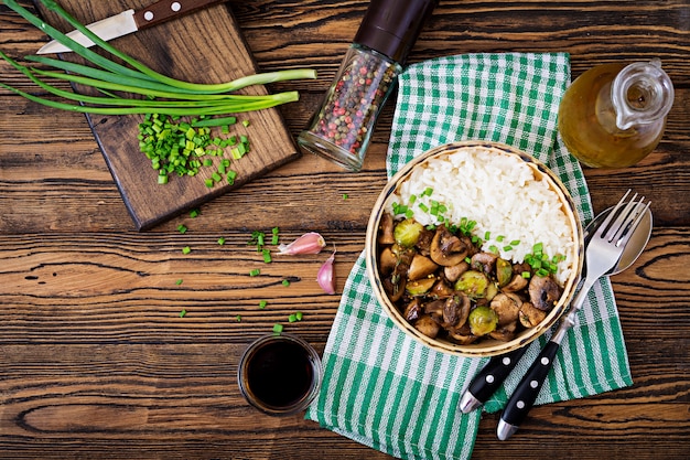 Menu vegano. comida dietética. arroz cozido com cogumelos e couve de bruxelas em estilo asiático. vista do topo. postura plana.