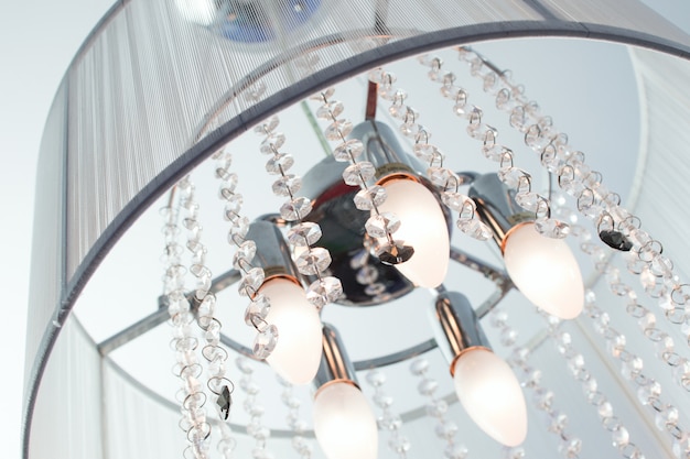 A menudo, los candelabros de inclusión con cristales y pantalla de tela en el techo