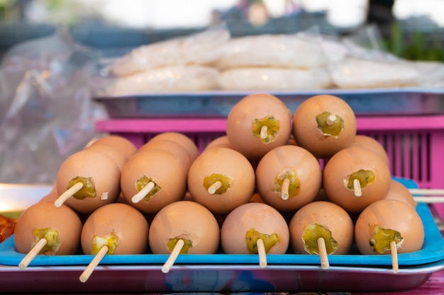 Mercado de alimentos asiáticos. Contador con huevos de gallina fritos en un palo