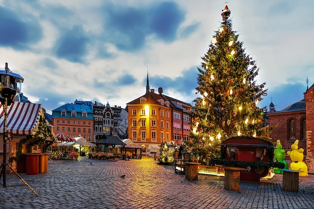 Mercado de Natal e a principal árvore de Natal localizada na praça Dome na antiga Riga, Letônia. No mercado as pessoas podem comprar lembranças festivas, presentes. Foco seletivo