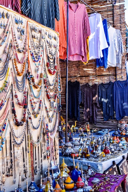 Un mercado con mucha ropa colgada del techo y joyas