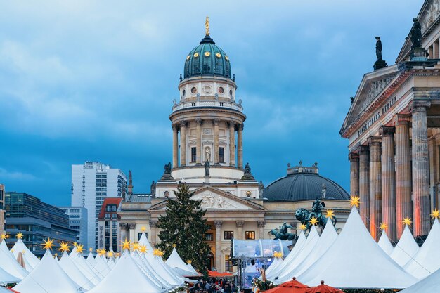 Mercado navideño nocturno en Gendarmenmarkt en Berlín en invierno, Alemania. Feria de Adviento Decoración y Puestos con Artículos de Artesanía en el Bazar.