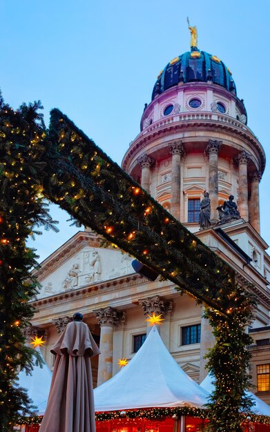 Mercado navideño nocturno en Gendarmenmarkt en Winter Berlin, Alemania. Calle de la tarde alemana Navidad y feria de vacaciones en la ciudad europea. Decoración de Adviento y puestos con artículos artesanales en el bazar