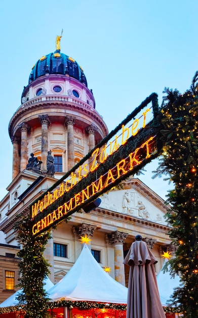 Foto mercado navideño nocturno de gendarmenmarkt en winter berlin, alemania. feria alemana de navidad y vacaciones en la calle. decoración de adviento y puestos con artículos de artesanía en el bazar.