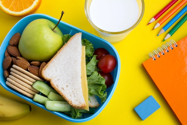 Merenda escolar na caixa no fundo amarelo