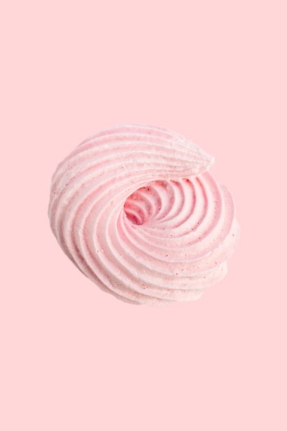 Foto merengue caramelo crema pastel rosa sobre fondo rosa claro.