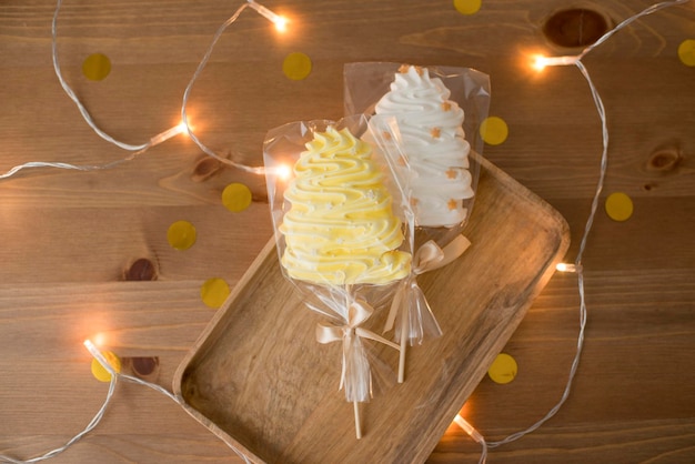 Merengue dulce en la mano, en un palo en forma de árbol de Navidad