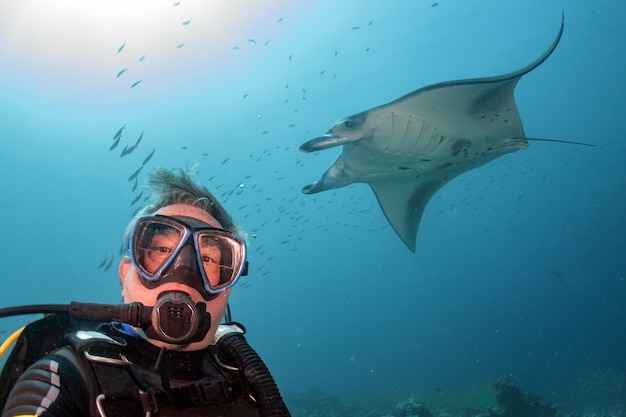 Foto mergulhador e manta no retrato de fundo do oceano azul