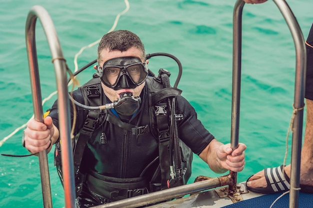 Mergulhador feliz retorna ao navio após o mergulho