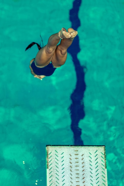 Mergulhador feminino pulando na piscina