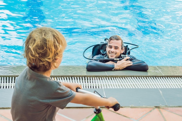 Mergulhador na piscina e menino