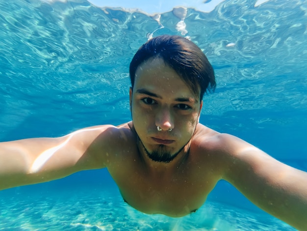 Mergulhador nadando no mar e tirando uma selfie nas férias