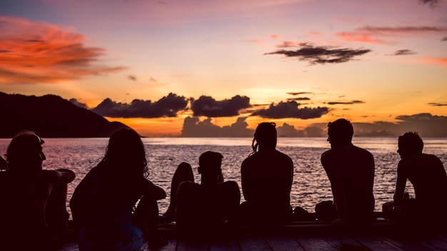 Mergulhadores de viajantes relaxando no cais em Sunset Kri Island Raja Ampat Indonésia Papua Ocidental