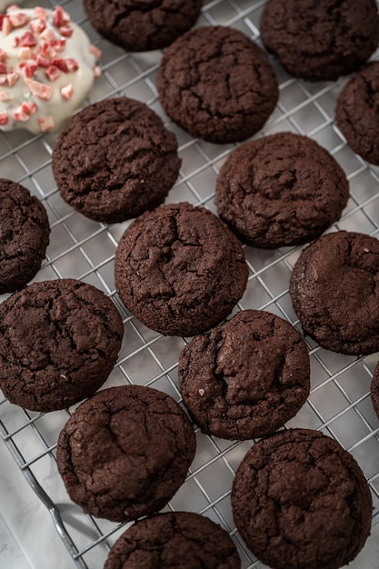 Mergulhando biscoitos de chocolate no chocolate branco derretido para preparar biscoitos de chocolate branco de menta