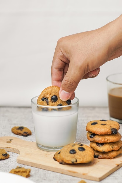 Foto mergulhando deliciosos biscoitos de chocolate no leite