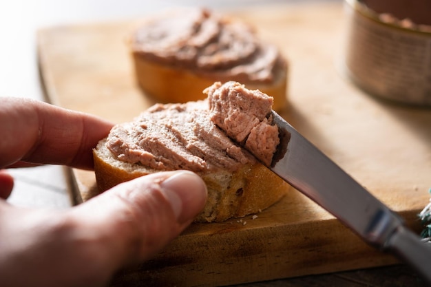 Mergulhando o pão torrado com patê de fígado de porco