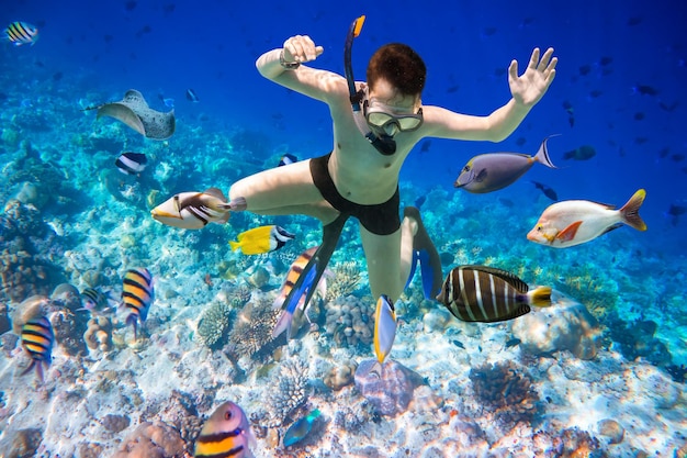 Mergulho com snorkel ao longo do coral cérebro. Maldivas - recife de coral do oceano. Aviso - tiro autêntico debaixo d'água em condições desafiadoras. Um pouco granulado e talvez borrado.