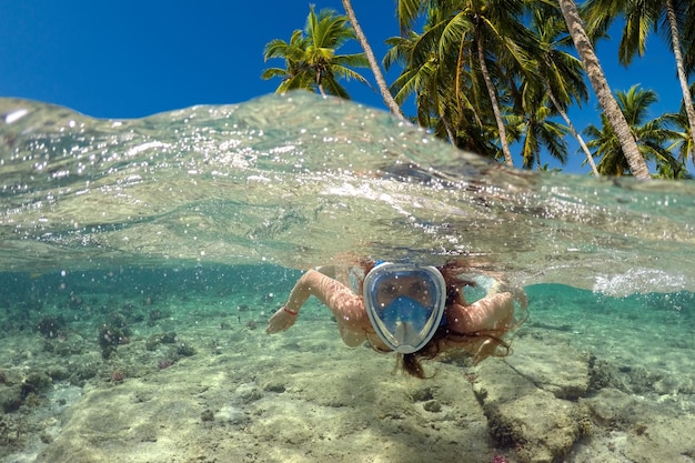 Mergulho perto de uma ilha tropical Linda garota nada na água Férias no mar