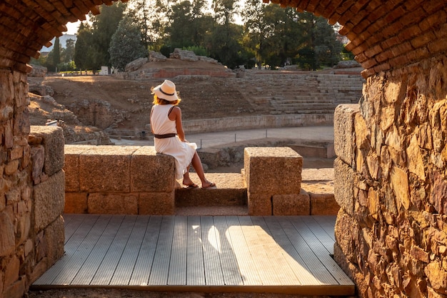 Merida Roman Ruins eine junge Frau, die sitzt und das römische Amphitheater Estremadura betrachtet