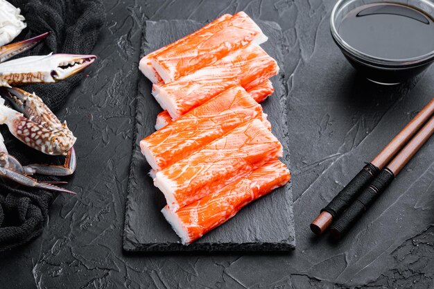 Merienda asiática surimi en tablero de piedra sobre fondo negro