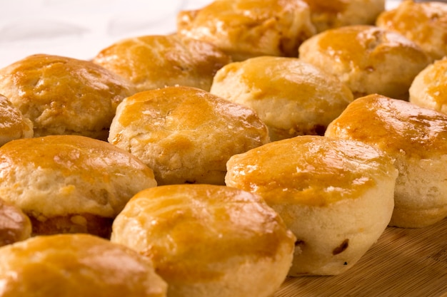 Merienda brasileña Empada. Pastel de pollo en un plato blanco sobre fondo de madera