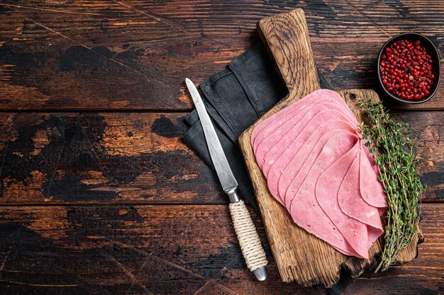 Foto merienda de jamón de res en rodajas sobre tablero de madera fondo de madera vista superior espacio de copia