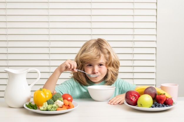 Merienda matutina con muesli cereal granola retrato de niño comer alimentos frescos y saludables en la cocina en casa