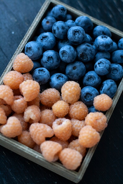 Una merienda sabrosa y saludable: una caja de frambuesas y arándanos.