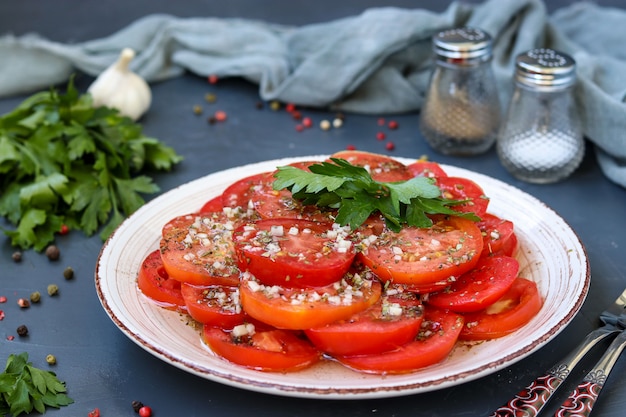 Merienda de tomates con ajo, perejil, aderezado con miel y aceite de oliva ubicado en un plato