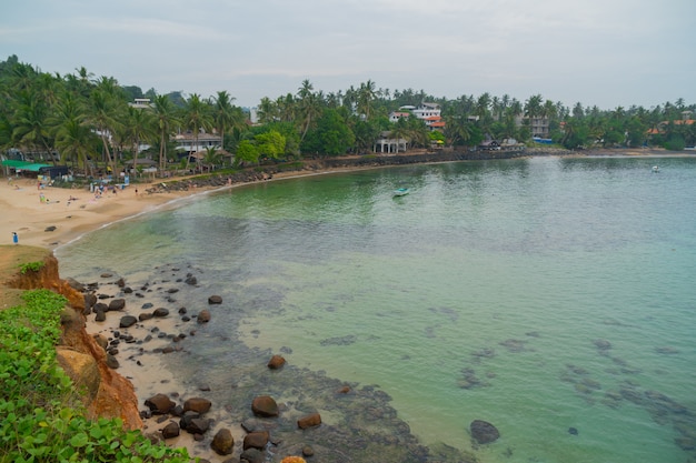 Merissa, Sri Lanka, papagaio. Pedregulhos enormes na praia.