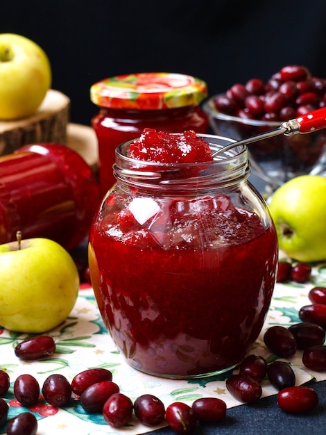 Mermelada casera de cornejos y manzanas en frascos con manzanas alrededor