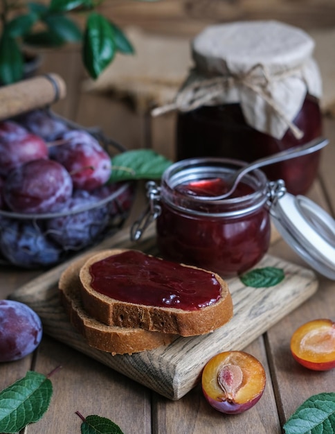 Foto mermelada de ciruela casera y bayas frescas sobre un fondo de madera concepto de conservación casera