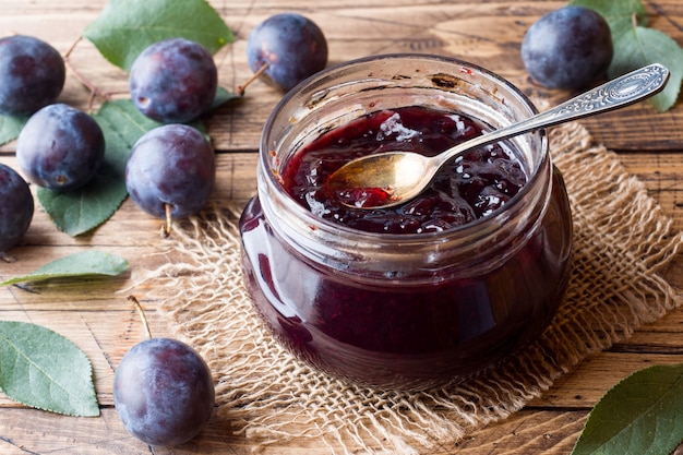 Mermelada de ciruela en un frasco de vidrio. Ciruela fresca