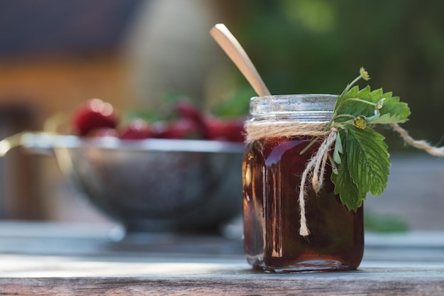 Mermelada de fresa en un frasco sobre una tabla de madera bayas fermentadas