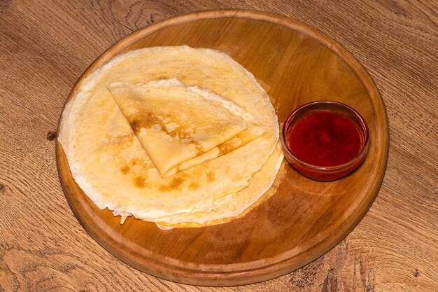 Mermelada de fresa en una pila de panqueques. Blini ruso sobre la mesa.