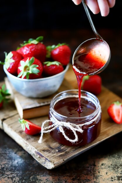 La mermelada de fresa se vierte en un frasco.