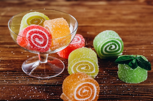 Mermelada de frutas multicolores se encuentra sobre una mesa de madera