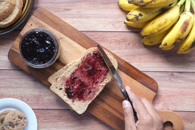 Mermelada de frutos rojos en pan en la mesa,