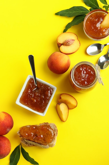 Mermelada de melocotón e ingredientes sobre fondo amarillo