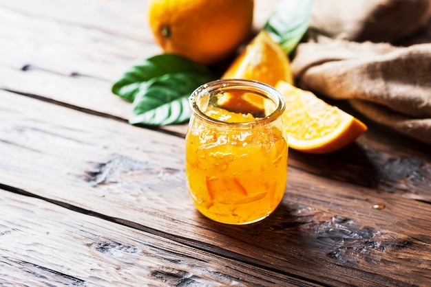 Mermelada de naranja dulce casera sobre la mesa de madera, el enfoque selectivo