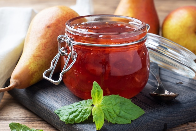 Mermelada de pera casera en un frasco y peras frescas